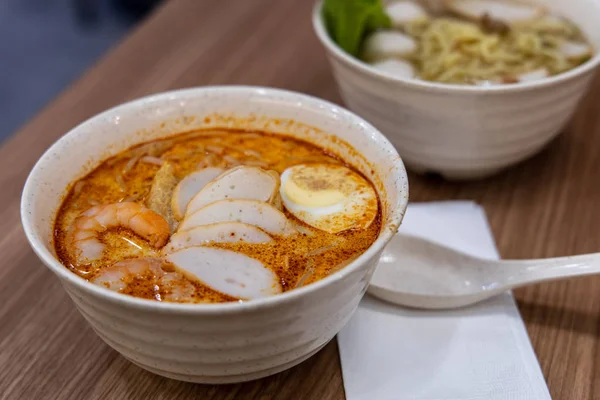 Laksa ist eine würzige Nudelsuppe, die in der peranakanischen Küche Südostasiens beliebt ist — Stockfoto