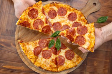 Pepperoni pizzası masada.