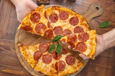 Pepperoni pizzası masada.