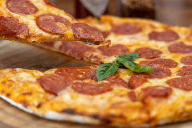 Pepperoni pizzası masada.