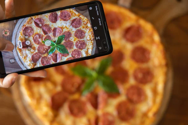 Pepperoni pizza with mobile phone
