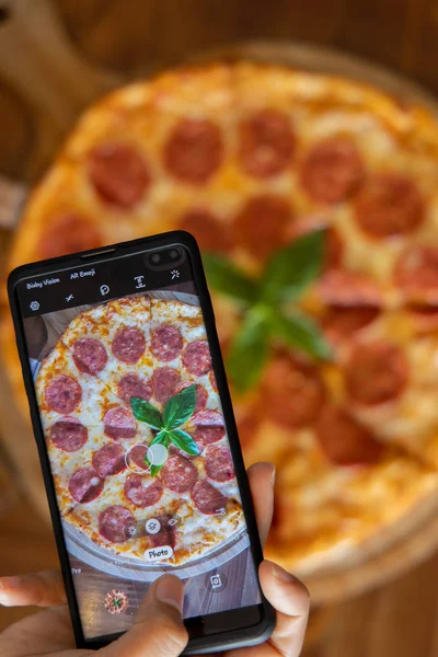 Pepperoni pizza with mobile phone