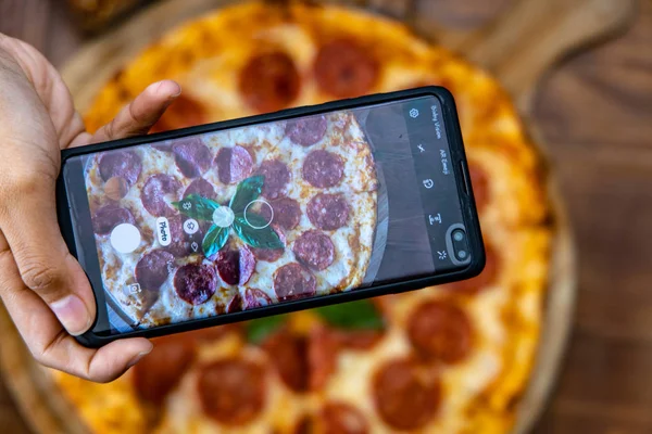 Pepperoni pizza with mobile phone