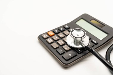 Hesap makinesi ve steteskop beyaz arka plan sağlık temalı fotokopi alanı. Sağlık giderleri veya sağlık sigortası.