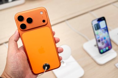 Hand holding a new iPhone 17 Pro Max in a Store.