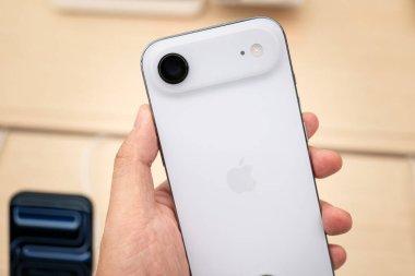 Hand holding a new iPhone 17 Air in a Store.