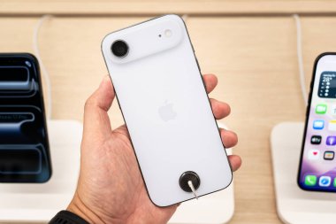 Hand holding a new iPhone 17 Air in a Store.