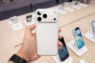 Hand holding a new Silver iPhone 17 Pro Max in a Store.