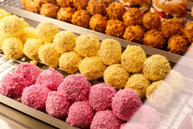 Pastanedeki Renkli Tatlı Topları Sergisi. Çeşitli tatlı ikramları, canlı renkler ve lezzetli dokular. Şekerleme, tatlı dükkanı ve yemek fotoğrafçılığı için mükemmel temalar..