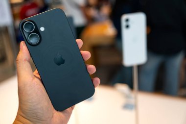 Hand holding a new iPhone 17 in an Apple Store Central World.