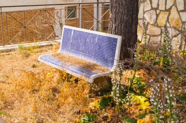 Küçük kare mavi mozaikten yapılmış yuvarlak tezgah Kuzey Sicilya 'da Kuru Çim brindillles ile bir ağaç altında vazgeçmek