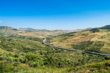 Dört şeritli otoyol kırsal ve Kuzeybatı Sicilya'nın tepeleri giderek
