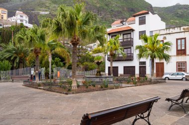 Banklar ve şehirde palmiye ağaçları ile küçük kare 