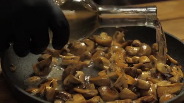 Koch gibt gebratene Pilze in Pfanne mit Wein zu — Stockvideo