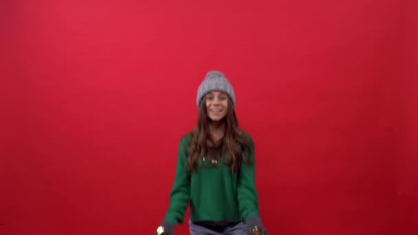 Menina joga ouro confetti em um fundo vermelho — Vídeo de Stock