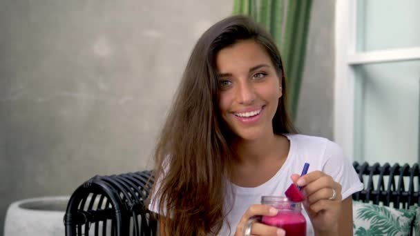 Bruna dalla pelle scura si siede in un caffè e beve frullato — Video Stock