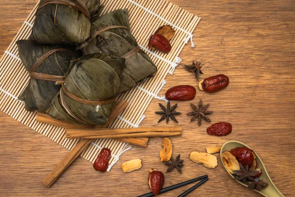 Zongzi veya Dragon Boat Festivali veya hamur tatlısı Festivali için ahşap bir masa bambu yaprağına geleneksel Çin pirinç köfte