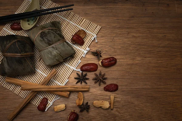 Zongzi またはドラゴンのボートの祝祭または団子祭の木製テーブルの笹の葉に伝統的な中国のお団子 — ストック写真