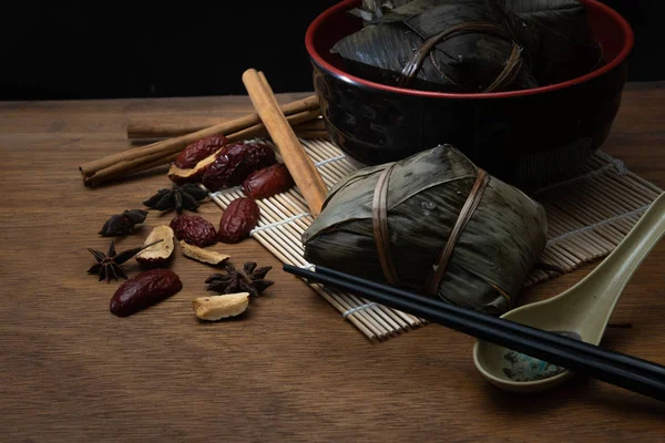 Zongzi veya Dragon Boat Festivali veya hamur tatlısı Festivali için ahşap bir masa bambu yaprağına geleneksel Çin pirinç köfte