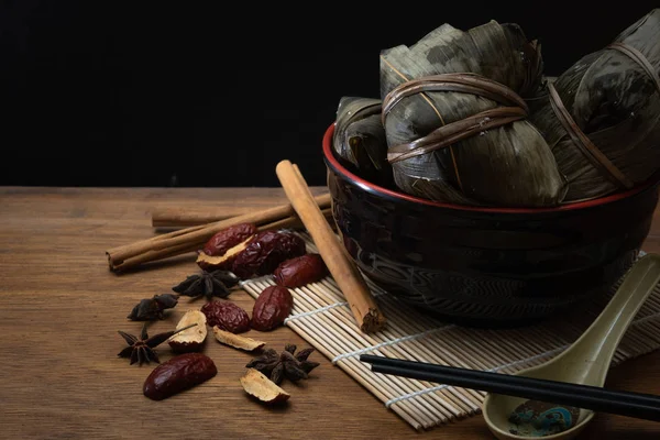 Zongzi veya Dragon Boat Festivali veya hamur tatlısı Festivali için ahşap bir masa bambu yaprağına geleneksel Çin pirinç köfte