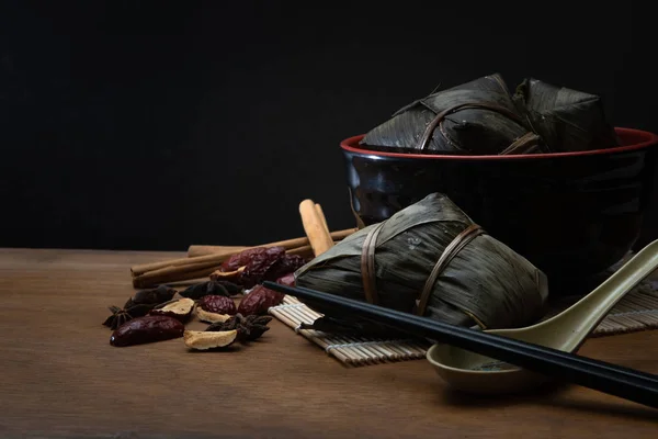 Zongzi またはドラゴンのボートの祝祭または団子祭の木製テーブルの笹の葉に伝統的な中国のお団子 — ストック写真