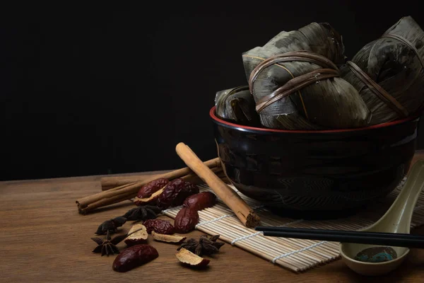 Zongzi またはドラゴンのボートの祝祭または団子祭の木製テーブルの笹の葉に伝統的な中国のお団子 — ストック写真