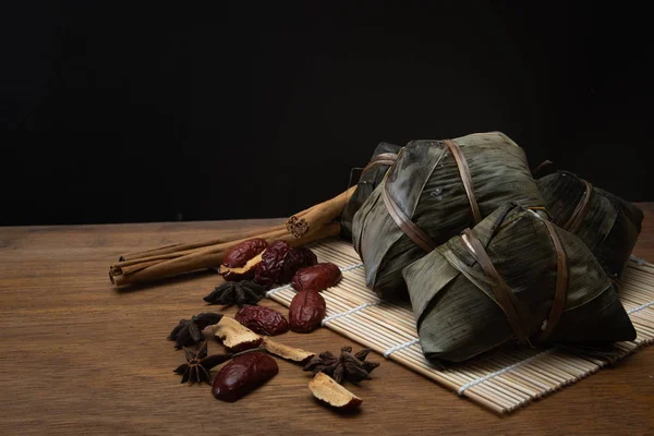 Zongzi veya Dragon Boat Festivali veya hamur tatlısı Festivali için ahşap bir masa bambu yaprağına geleneksel Çin pirinç köfte