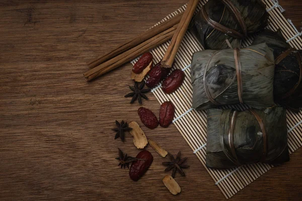 Zongzi veya Dragon Boat Festivali veya hamur tatlısı Festivali için ahşap bir masa bambu yaprağına geleneksel Çin pirinç köfte