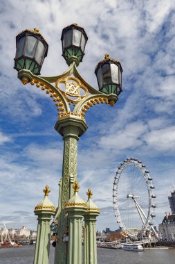 Westminster Bridge güzel sokak lambası, London Eye, arka planda görülen şehrin popüler Simgesel Yapı ile Londra'da Thames Nehri üzerinde eski köprü