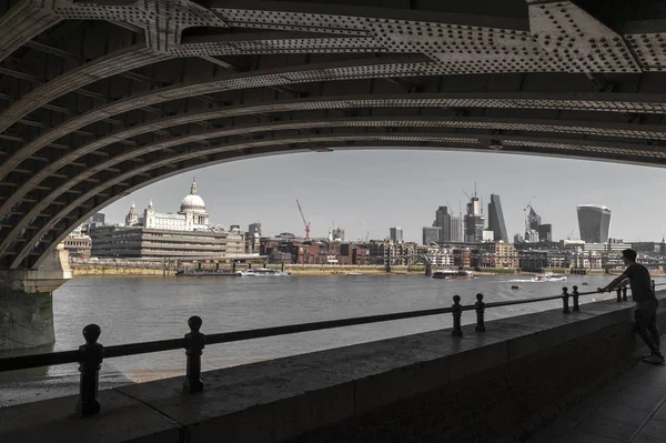 London, UK - April 2018: Riverbank of the Thames under Blackfriars Bridge with St Paul Cathedral, famous and recognizable religious sight of London in England, UK