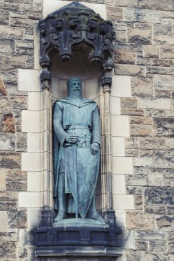 Edinburgh, Scotland - April 2018: Statues of William Wallace by Alexander Carrick at the Gatehouse, main entrance to Edinburgh Castle, popular tourist attraction and landmark of Edinburgh City, Scotland, UK clipart