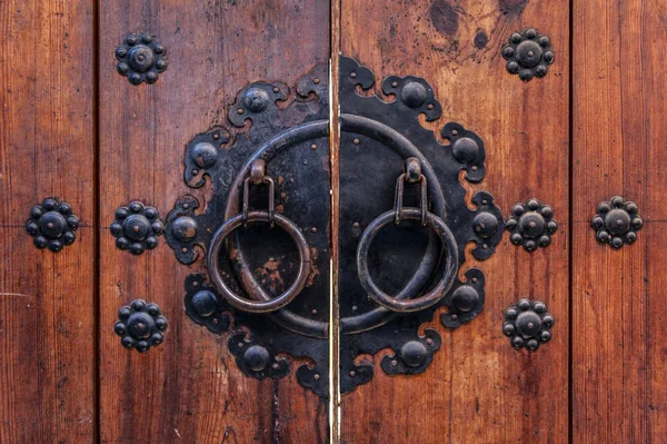 Panneaux de porte en bois coréens décorés de vieilles poignées en anneau métallique noir dans une maison dans un ancien village de Jeonju, Corée du Sud — Photo