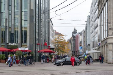 Leipzig, Almanya - Ekim 2018: Leipzig şehir merkezinde, Augustusplatz yakınlarındaki merkezi iş bölgesi ve şehir meydanında eski binaların yanında sokaktayayalar