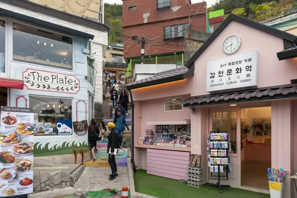 Busan, Coreia do Sul - abril de 2019: Turistas visitam Gamcheon Culture Village, famosa atração com casas vibrantemente pintadas decoradas com murais e esculturas na encosta da montanha costeira em Busan, Coreia do Sul — Fotografia de Stock