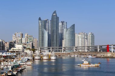 Busan, Güney Kore-Nisan 2019: Minlaghang Fisherman Wharf Haeundae bölgesi 'nde Marine City gökdelenler ve Busan, Güney Kore Gwangandaegyo Köprüsü (Diamond Bridge) tarafından geri döneli