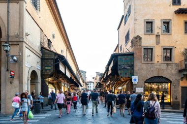 Floransa, İtalya - Ekim 2019: Floransa, İtalya 'da Arno Nehri üzerine inşa edilmiş, ortaçağ taş kemer köprüsü olan ünlü Ponte Vecchio (Eski Köprü) üzerinde yürüyen turistler