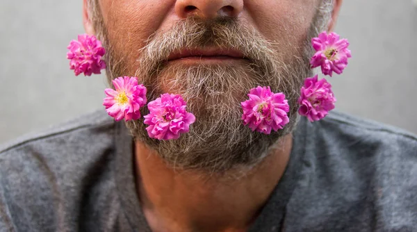 Brutal man with flowers in his beard.