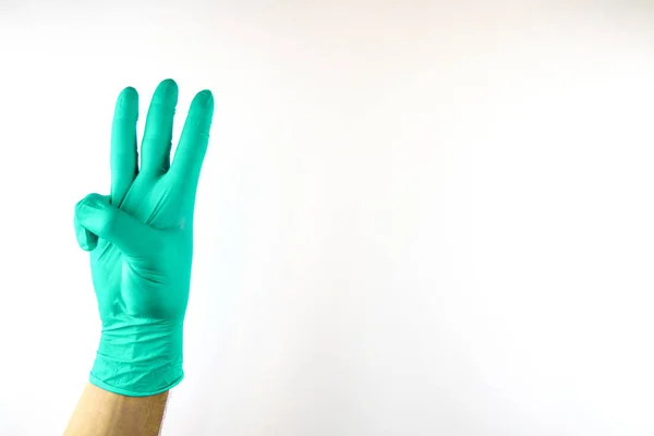 Mužská ruka v lékařské rukavici na bílém pozadí. — Stock fotografie
