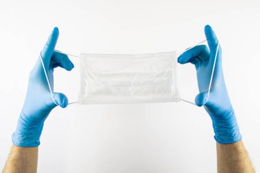 Tıbbi eldiven ler giyen, tıbbi maske takan Erkek elleri.