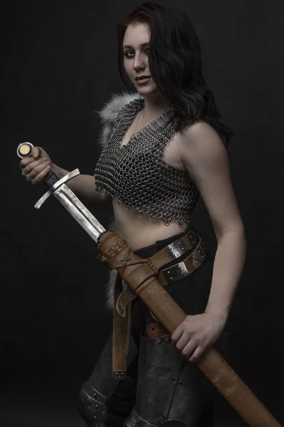 Girl knight in chain mail with fur with a sword in her hands — Stock Photo, Image