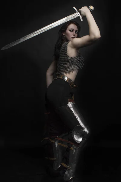 girl knight in chain mail with fur with a sword in her hands