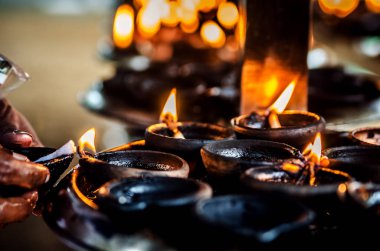 Mümin bir Budist tapınağında bir mum yanar. Kalutara. Sri Lanka.