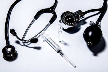 Phonendoscope, tanomert ve beyaz bir yüzeye bir ampul şırınga.