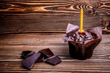 Festival çikolatalı muffin ve siyah bir ahşap yüzey üzerinde çikolata parçalarını.