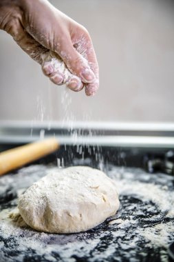 Masanın üzerinde yatan un ile hamur Cook sprinkles.