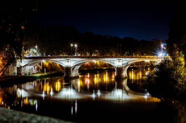 Tiber Nehri gidiş ışıklı köprü bir bakış gece. Roma. İtalya.