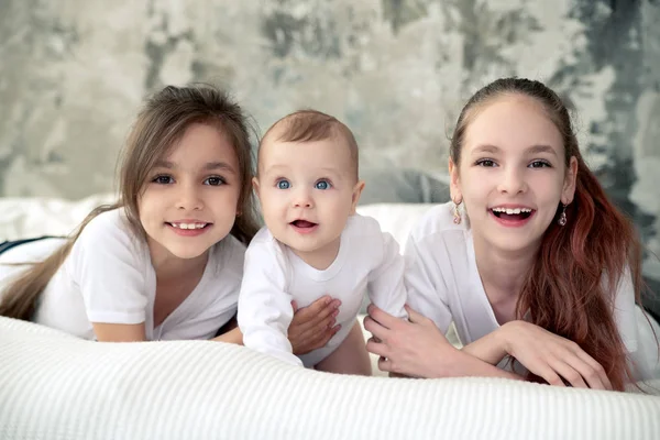 Three sisters smile all together.