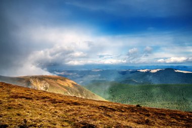 Zaroslyak Dağı 'ndan dağlara ve üzerlerinde süzülen bulutlara bakın. Karpatlar. Ukrayna.