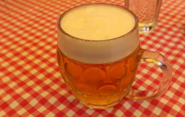 in the glass on the table in the restaurant is a fresh beer