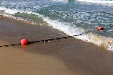 En banyo plaj yüzen bir ip ile çit yer 